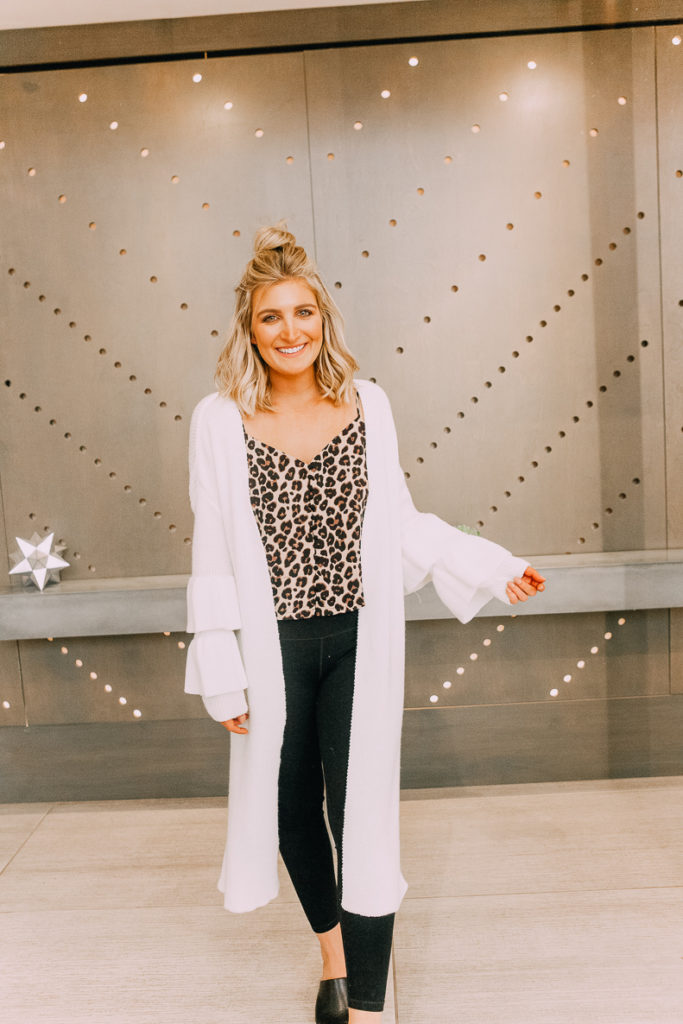 How To Style Leggings For Work featured by top US fashion blogger Audrey Madison Stowe; Image of a woman wearing a Aria Rose leopard tank and Nordstrom Rack long white duster.