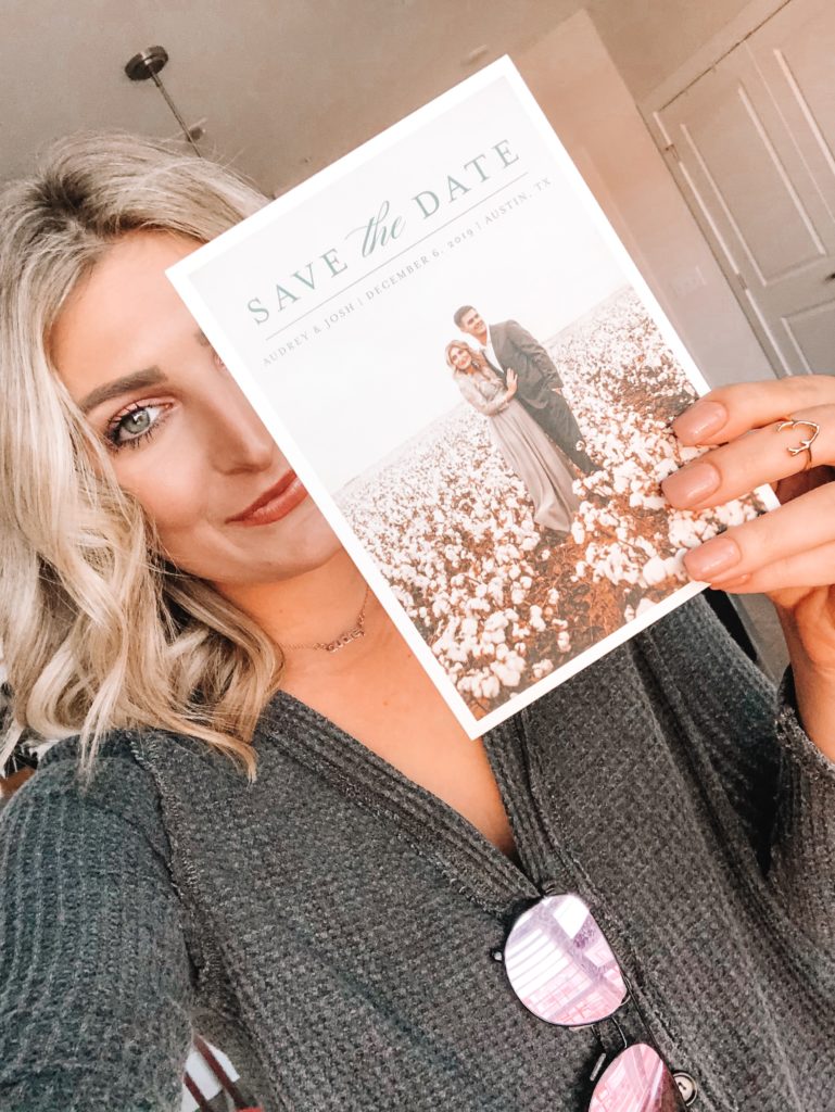 Save The Date Ideas featured by top US lifestyle blogger Audrey Madison Stowe; Image of woman holding a save the date card.